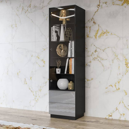 Tall black bookshelf with decorative items against a marble wall