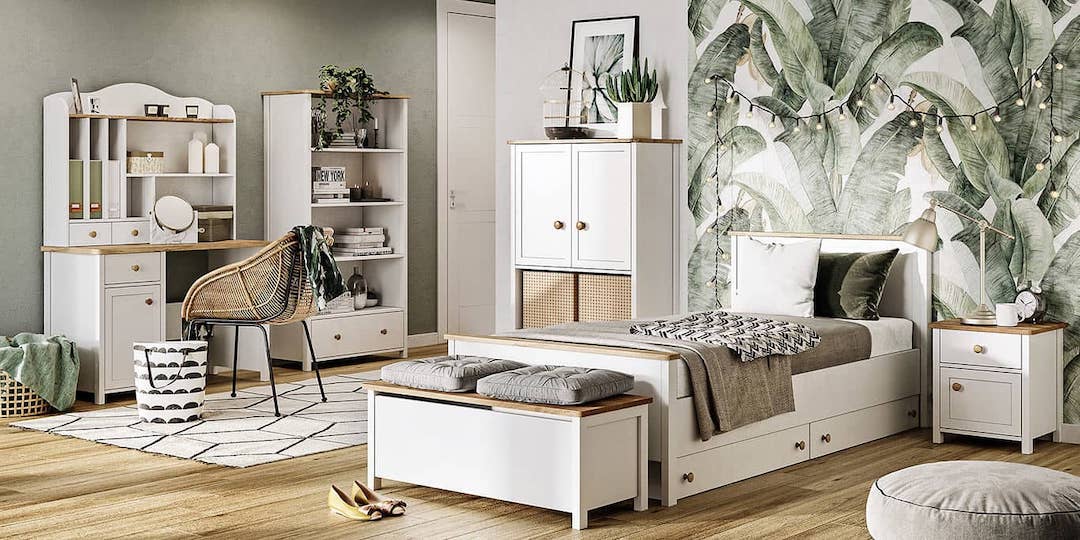 Modern bedroom with white furniture, green plants, and a large floral wall mural.