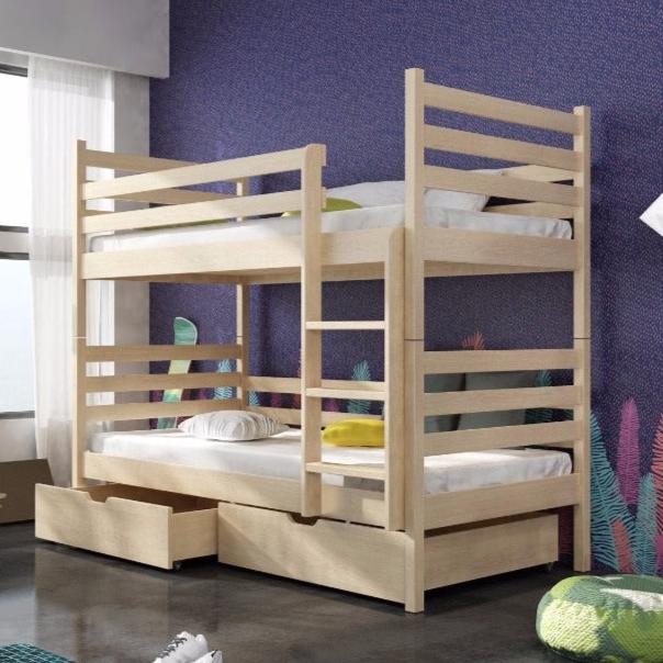 Wooden bunk bed with storage drawers in a room with purple walls and colorful decorations.