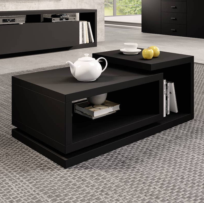 Black coffee table with a teapot and books in a living room setting