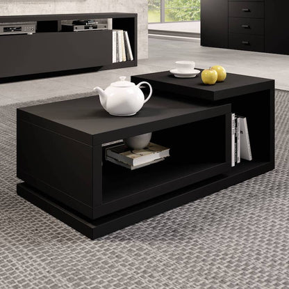 Black coffee table with a teapot and books in a living room setting