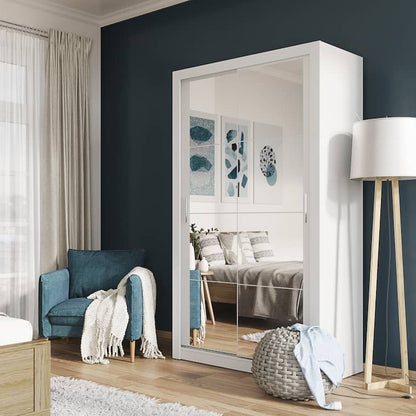 Modern bedroom with large mirror, blue armchair, and wooden nightstands.