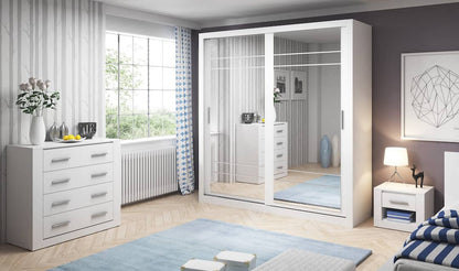 Modern bedroom with white wardrobe, dresser, and bed.