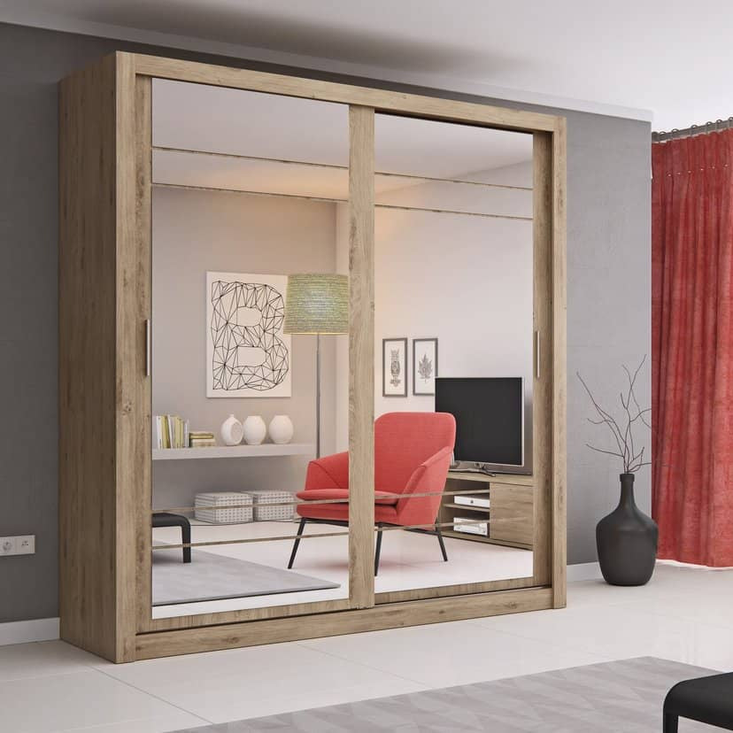 Wooden wardrobe with mirror in a living room setting with red chairs and decor.