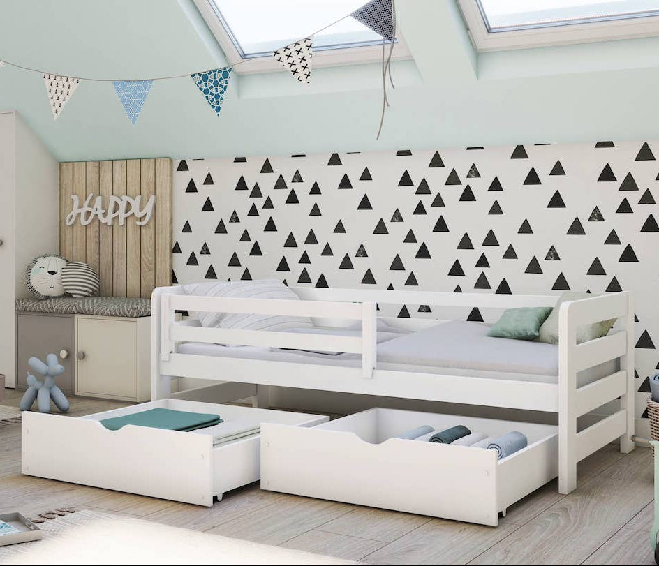 Children's room with a white bed, storage drawers, and decorative elements.
