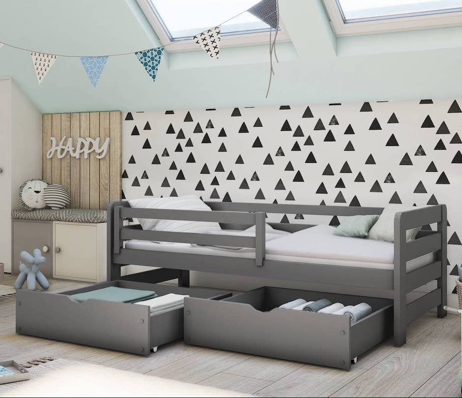 Children's room with a gray bed with storage drawers, patterned wallpaper, and toys.