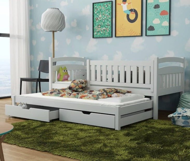 Children's bedroom with a white bed, green rug, and colorful wall art.