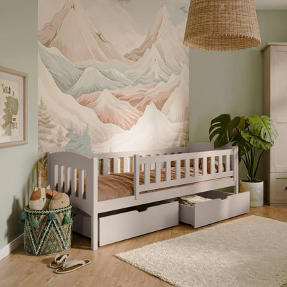 Children's room with a bed, mountain mural, and decorative items.