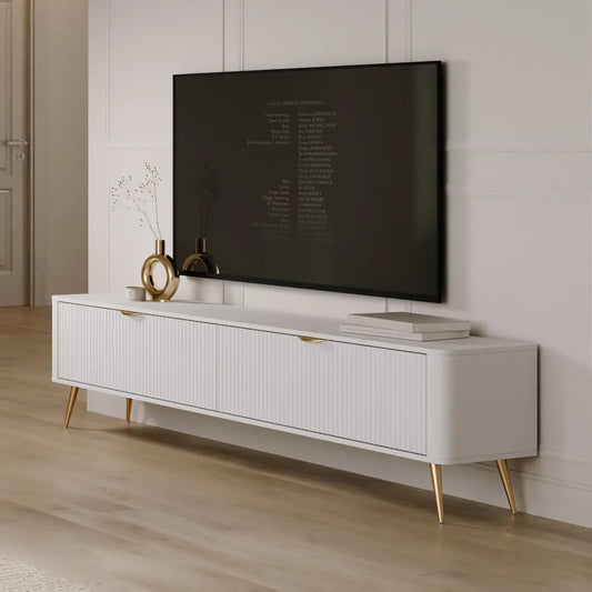 White TV stand with a mounted television displaying text, in a room with wooden flooring and a neutral wall.