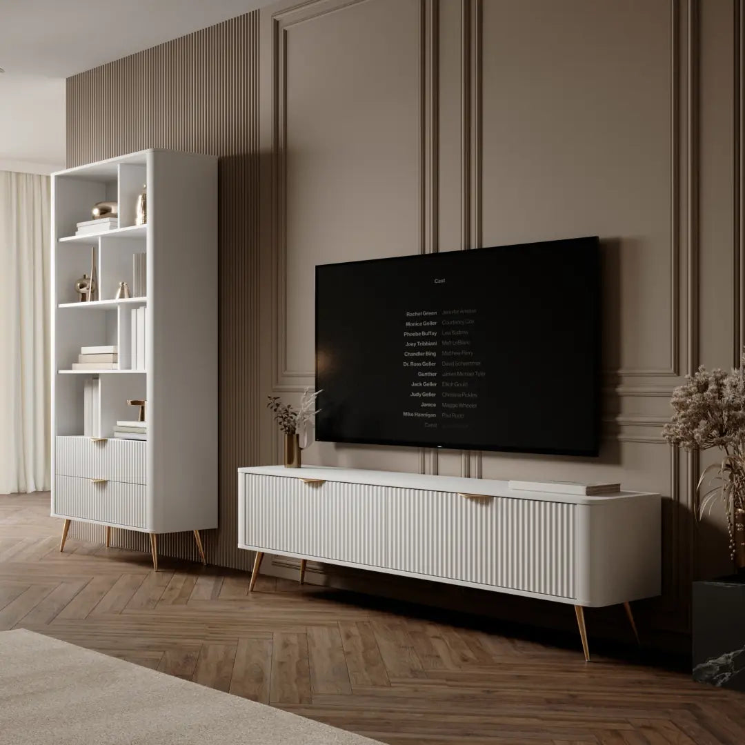 Modern living room with a television mounted on a wall, flanked by a white bookshelf and decorative elements.