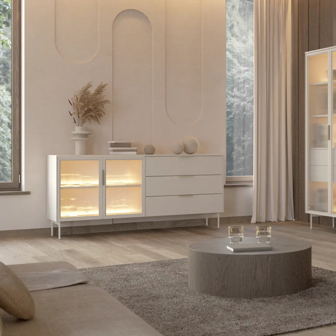 Modern living room with a white sideboard, round coffee table, and decorative elements.
