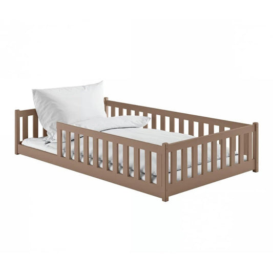 Wooden children's bed with white mattress and pillow on a white background