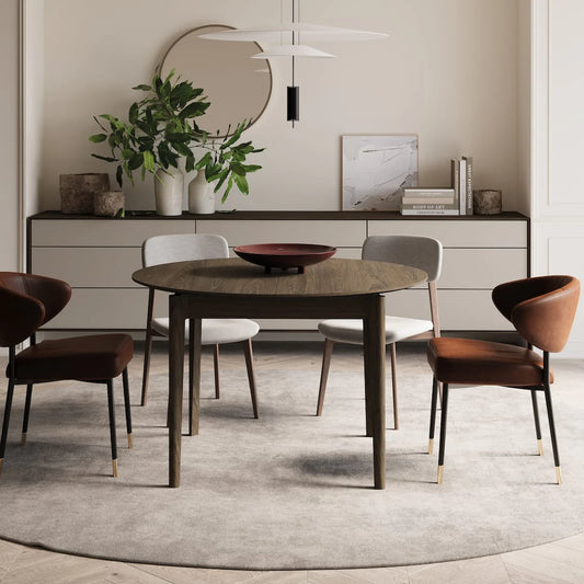 Dining room with a round wooden table and chairs, featuring a neutral color palette.
