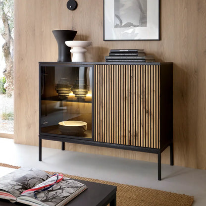 Modern black and wood sideboard with decorative items in a room with wooden walls.