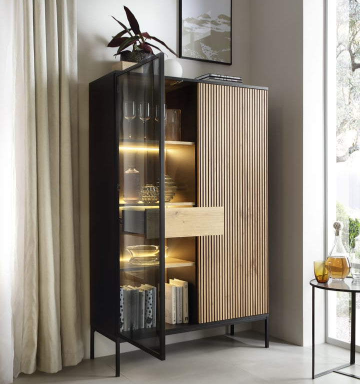 Modern interior with a tall black and wood cabinet against a light gray wall.