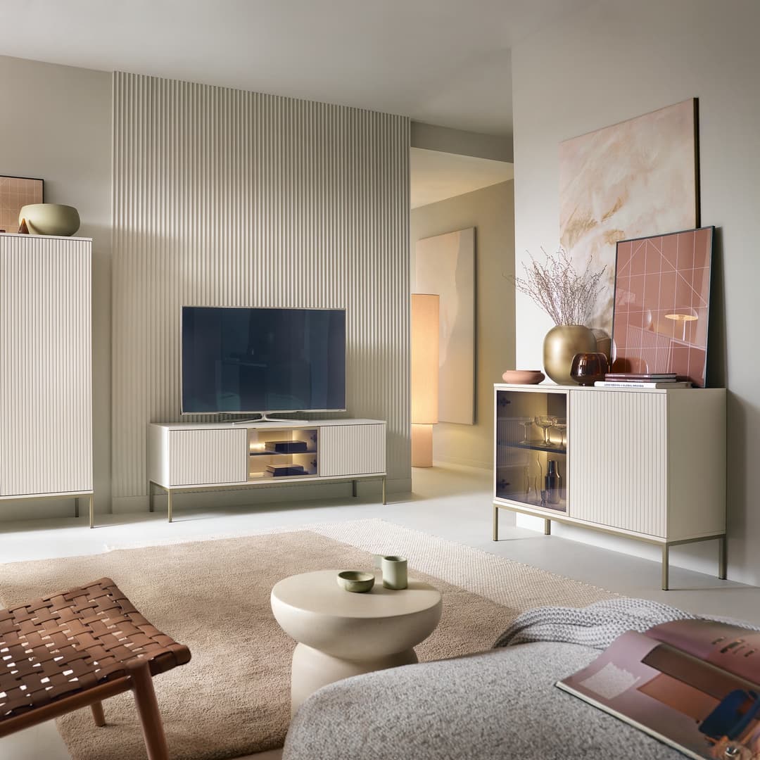 Modern living room with a television on a stand, sideboard, and decor items.