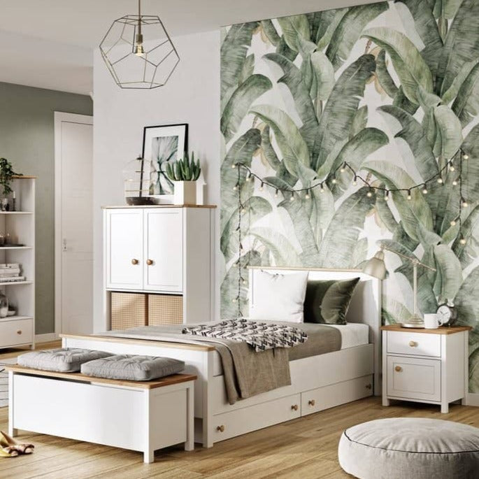 Modern bedroom with banana leaf wallpaper, white furniture, and decorative elements.