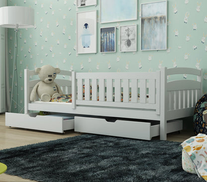 Children's room with a white crib, teddy bear, and decorative elements.