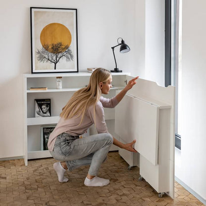 Woman in a modern home office setting with a desk and bookshelf.