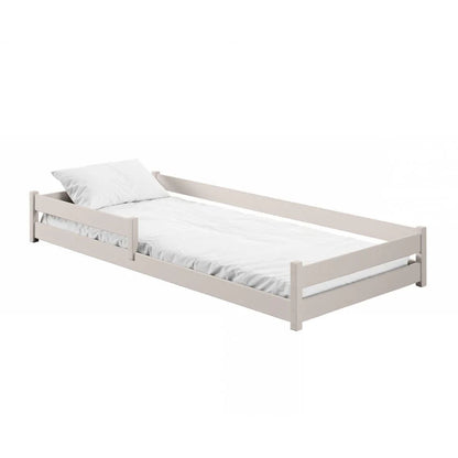 Beige single bed with white mattress and pillow on a white background