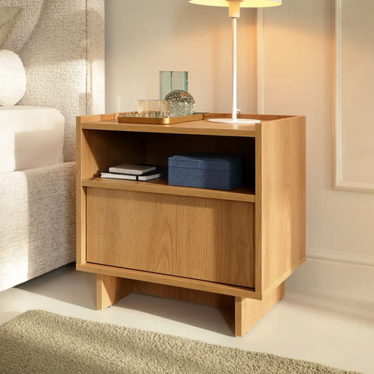 Wooden side table with a lamp and decorative items in a living room setting